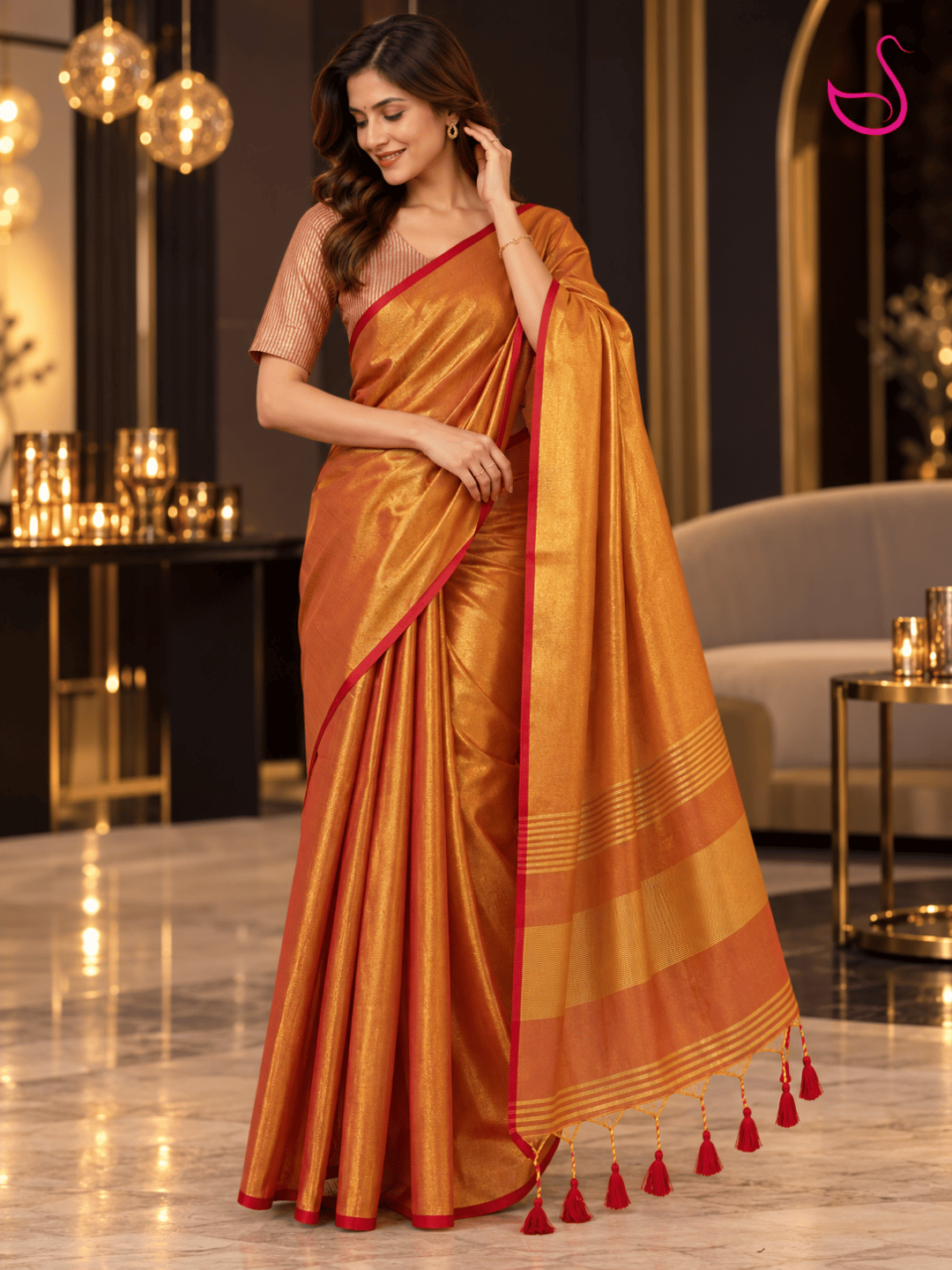 Golden-orange silk saree with red border and striped blouse, styled for a festive occasion