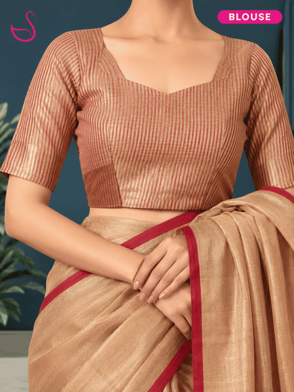 A woman wearing a metallic bronze short-sleeve blouse with a square neckline and a beige saree with a red border, shown against a dark blue background.