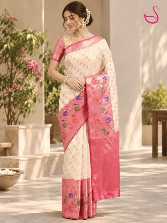 Cream woven saree with pink floral zari pallu and pink woven blouse, styled on a woman outdoors
